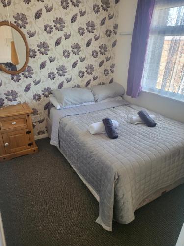 a bedroom with a bed with two towels on it at #31 Sundowner in Great Yarmouth