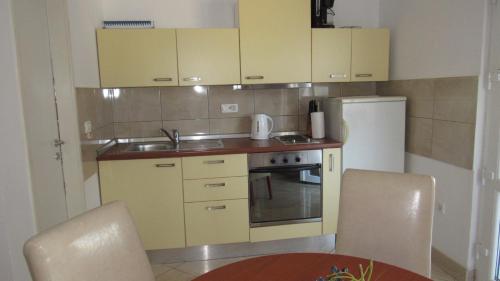 una pequeña cocina con fregadero y nevera. en Apartments with a parking space Sveti Filip i Jakov, Biograd - 18810 en Sveti Filip i Jakov