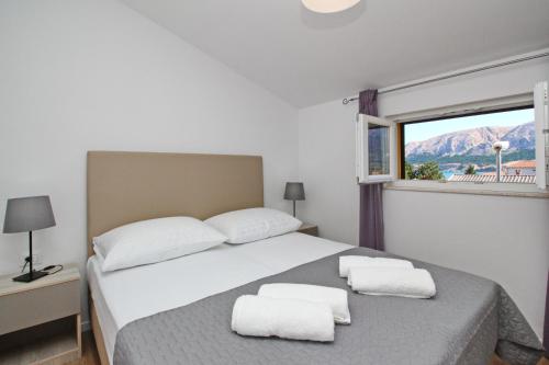 sypialnia z łóżkiem i dwoma ręcznikami na nim w obiekcie Apartments with a parking space Baska, Krk - 18793 w Bašce