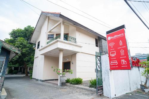 a building with a sign in front of it at RedDoorz near Rumah Sakit Baptis Kediri in Kediri