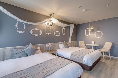 a bedroom with two beds and a table with a chair at Hotel Teiregikan in Tobe