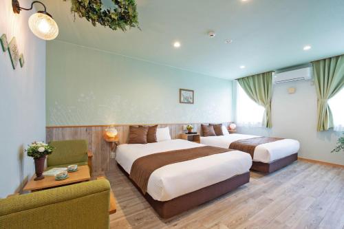 Tobeにあるホテル ていれぎ館のベッド2台とソファが備わるホテルルームです。