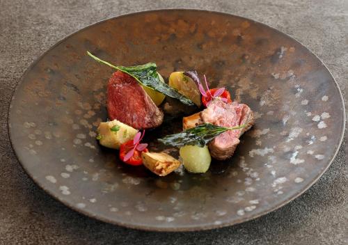 a brown plate with food on a table at Hotel Anaga in Minamiawaji