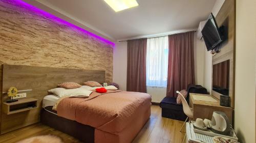una camera da letto con un grande letto con illuminazione viola di Rooms with a parking space Daruvar, Bjelovarska - 18842 a Daruvar
