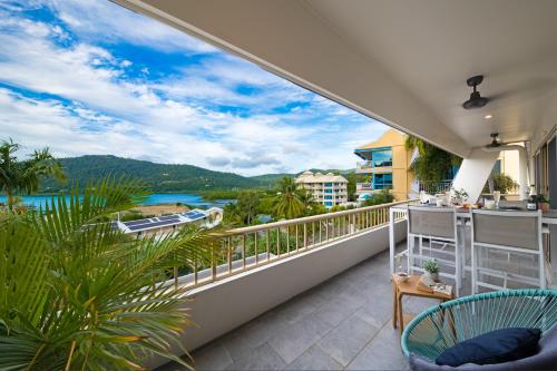 a balcony with a view of the water and mountains at Eagles Nest On Airlie in Airlie Beach