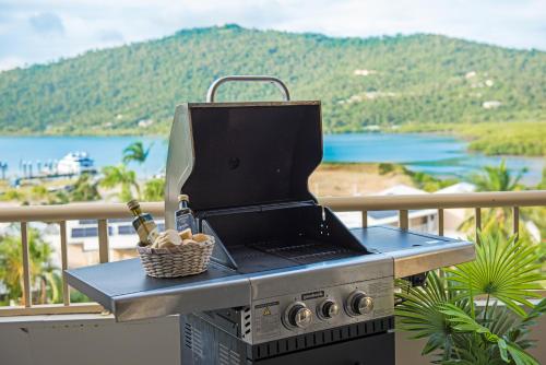 a grill on a balcony with a view of a mountain at Eagles Nest On Airlie in Airlie Beach