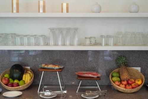 three baskets of fruit sitting on a counter with shelves at Terrakotta Rishikesh in Rishīkesh