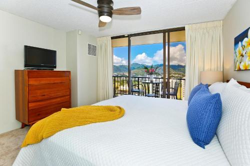 a bedroom with a bed and a large window at Waikiki Sunset #2807 in Honolulu