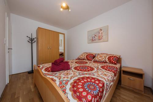 1 dormitorio con 1 cama grande con almohadas rojas en Apartments with a parking space Kastel Stari, Kastela - 18812, en Kaštela