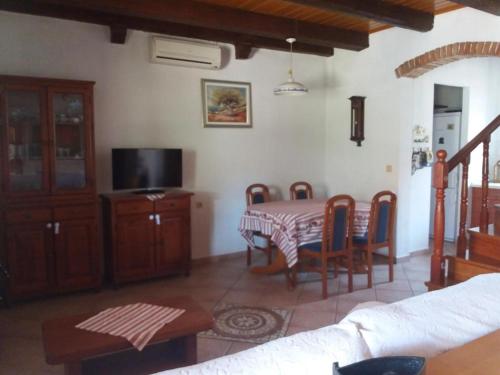 a living room with a table and a tv at Holiday house with a parking space Olib - 18805 in Olib