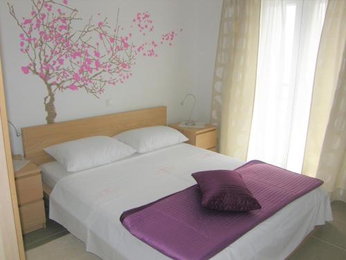 a bedroom with a bed with a purple blanket on it at Apartments with a parking space Baska, Krk - 18871 in Baška