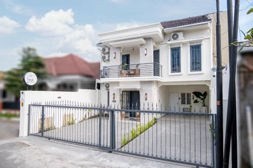 a white house with a gate in front of it at Villa Siji Plemburan in Kejayan