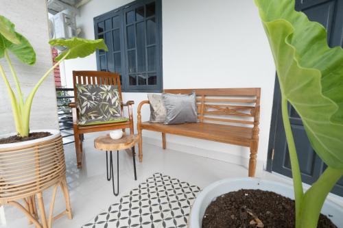 a porch with a bench and chairs and plants at Villa Siji Plemburan in Kejayan