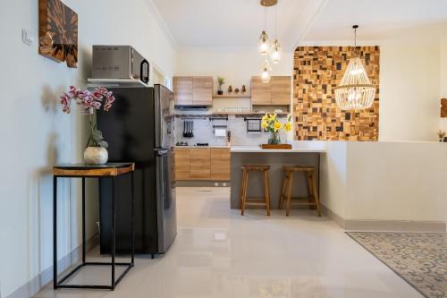 a kitchen with a black refrigerator and a counter at Villa Siji Plemburan in Kejayan