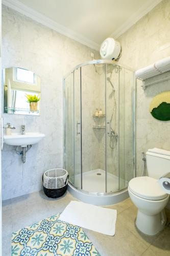 a bathroom with a shower and a toilet and a sink at Villa Siji Plemburan in Kejayan
