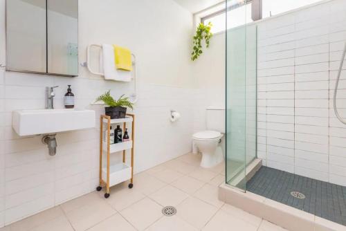 a bathroom with a shower and a sink and a toilet at Deluxe Mahuhu 2 BR - Spark Arena - FREE PARKING in Auckland