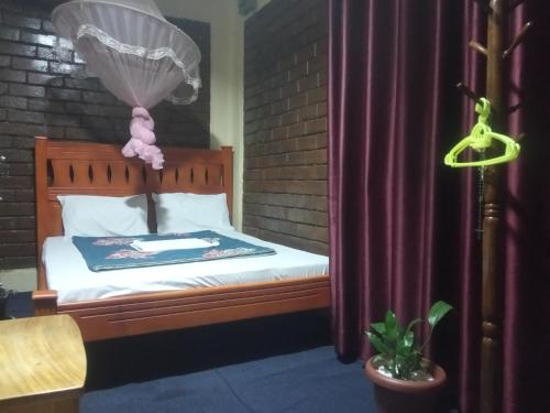um quarto com uma cama com uma cortina roxa em Plastic Bottles House em Entebbe