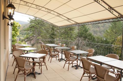 a row of tables and chairs on a balcony at Hôtel Restaurant Spa Le Sauvage in Besançon