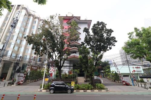 un coche aparcado frente a un edificio en Tamarin Hotel Jakarta manage by Vib Hospitality Management, en Yakarta