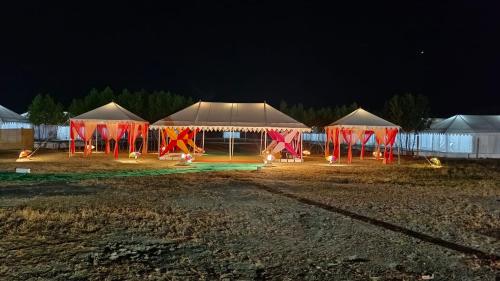 una fila de tiendas de campaña en un campo por la noche en Kutch Classic Resort Camp, en Dhordo