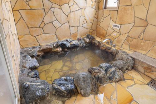 a pool of water in a room with rocks at Hotel Teiregikan in Tobe