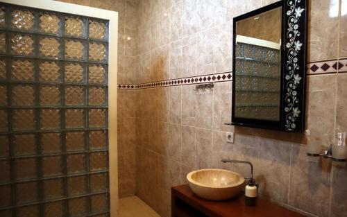 a bathroom with a sink and a mirror at Private pool Villa Sawah Sewon in Yogyakarta