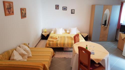 una camera d'albergo con due letti e un divano di Apartments with a parking space Soline, Krk - 18787 a Dobrinj