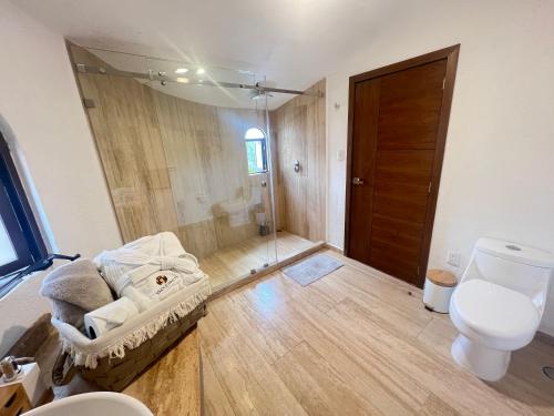 a bathroom with a toilet and a sink and a door at Loft Santiago Val’quirico in Tlaxcala de Xicohténcatl