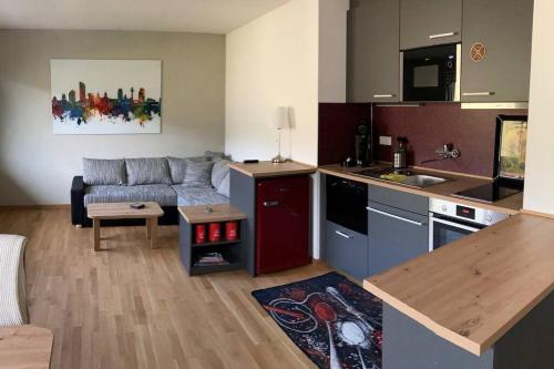 eine Küche und ein Wohnzimmer mit einem Sofa und einem Tisch in der Unterkunft Rhineview 549 - Rheinblick 549 im Mittelrheintal in Oberwesel