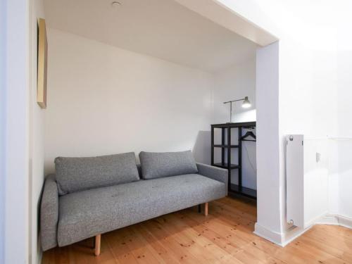 a living room with a couch in the corner at Sanders Park - One-Bedroom Apartment Near a Huge City Park in Copenhagen
