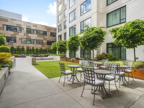 a patio with tables and chairs in front of a building at EVEN Hotel Seattle Downtown - Lake Union by IHG in Seattle