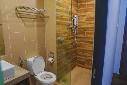 Roxy Hotel Serian في Serian: حمام مع مرحاض ودش زجاجي