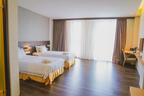 ein Hotelzimmer mit 2 Betten und einem Schreibtisch in der Unterkunft Roxy Hotel Serian in Serian