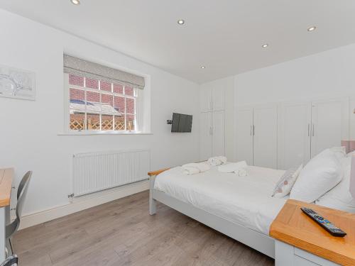 a white bedroom with a bed and a window at Flat 4B in Chester