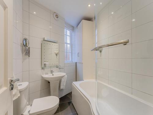 een witte badkamer met een toilet en een wastafel bij Flat 4B in Chester