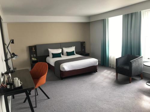 a bedroom with a bed and a desk and a chair at Holiday Inn Doncaster A1- M Jct 36 by IHG in Doncaster