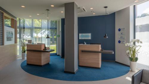 an office with a reception area with blue walls at Holiday Inn Express - Krefeld - Dusseldorf by IHG in Krefeld