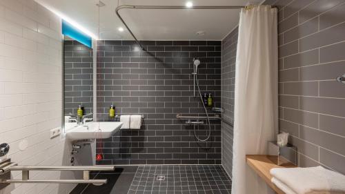ein Bad mit einem Waschbecken und einer Dusche in der Unterkunft Holiday Inn Express - Krefeld - Dusseldorf, an IHG Hotel in Krefeld