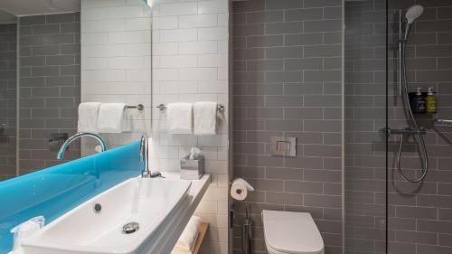 a bathroom with a tub and a toilet and a shower at Holiday Inn Express - Krefeld - Dusseldorf by IHG in Krefeld