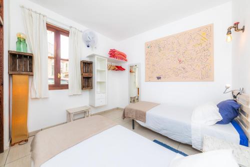 a bedroom with two beds and a painting on the wall at Es Cantonet in Porto Cristo