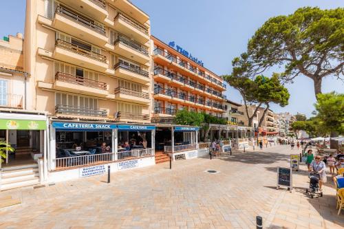 a street with people sitting outside of a building at Es Cantonet in Porto Cristo