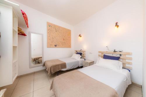 1 dormitorio con 2 camas y espejo en Es Cantonet, en Porto Cristo
