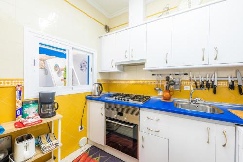 a kitchen with white cabinets and a sink at Es Cantonet in Porto Cristo