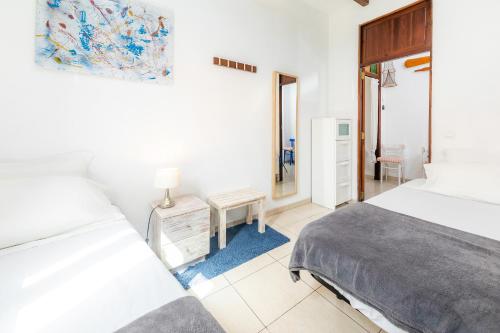a bedroom with two beds and a table and a mirror at Es Cantonet in Porto Cristo