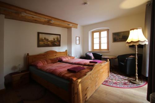 a bedroom with a bed and a lamp in a room at Pension und Falknerei an der alten Schmiede in Bernstadt