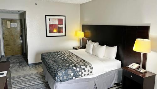 a hotel room with a large bed and two lamps at Super Inn & Suites Philadelphia in Philadelphia