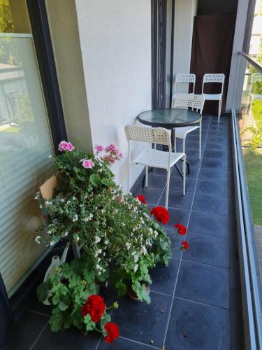 a balcony with a table and chairs and flowers at Apartamentai Muziejaus g. in Birštonas