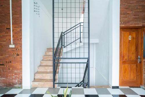 a staircase in a building with a wooden door at RedDoorz syariah @ Selomangleng Kediri in Kediri