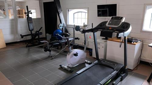 a room with a gym with bikes and a treadmill at Ingridgården in Båstad