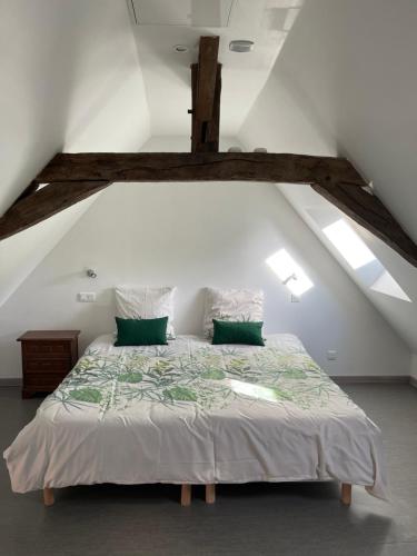 een slaapkamer met een groot bed op zolder bij Le coin des Halles dans le vignoble de Bourgueil in Bourgueil